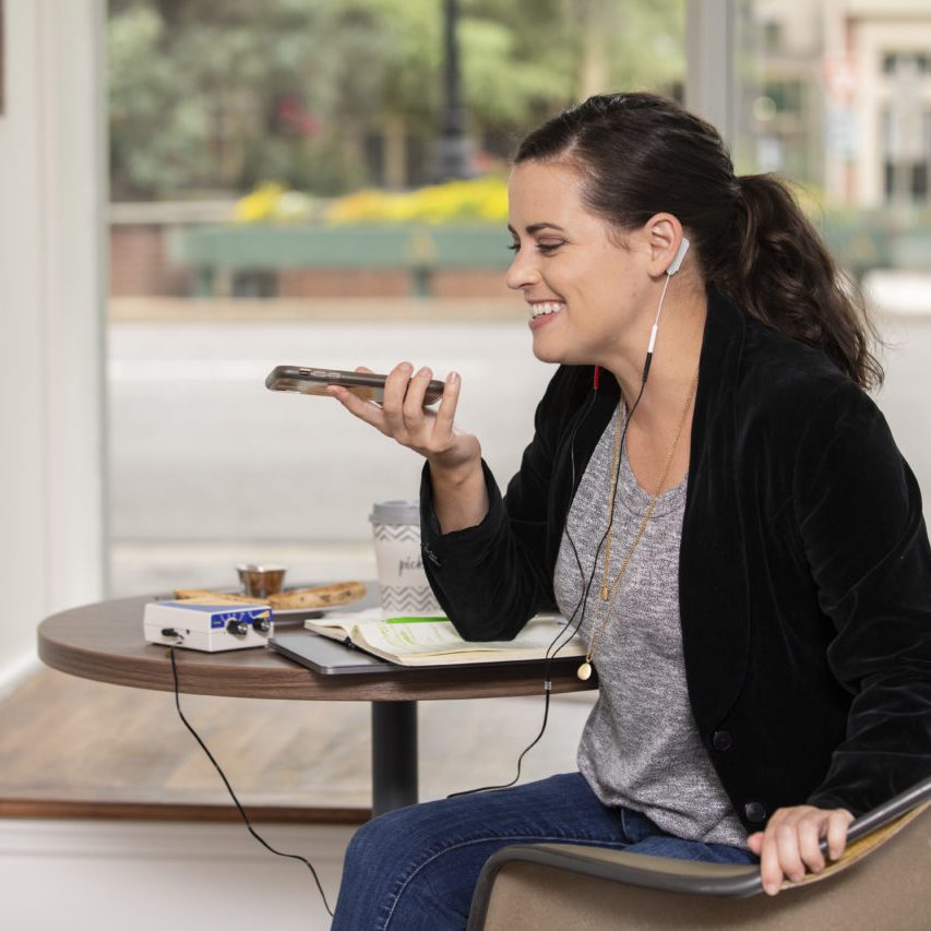 Female using Neba UpLink device in a coffeeshop